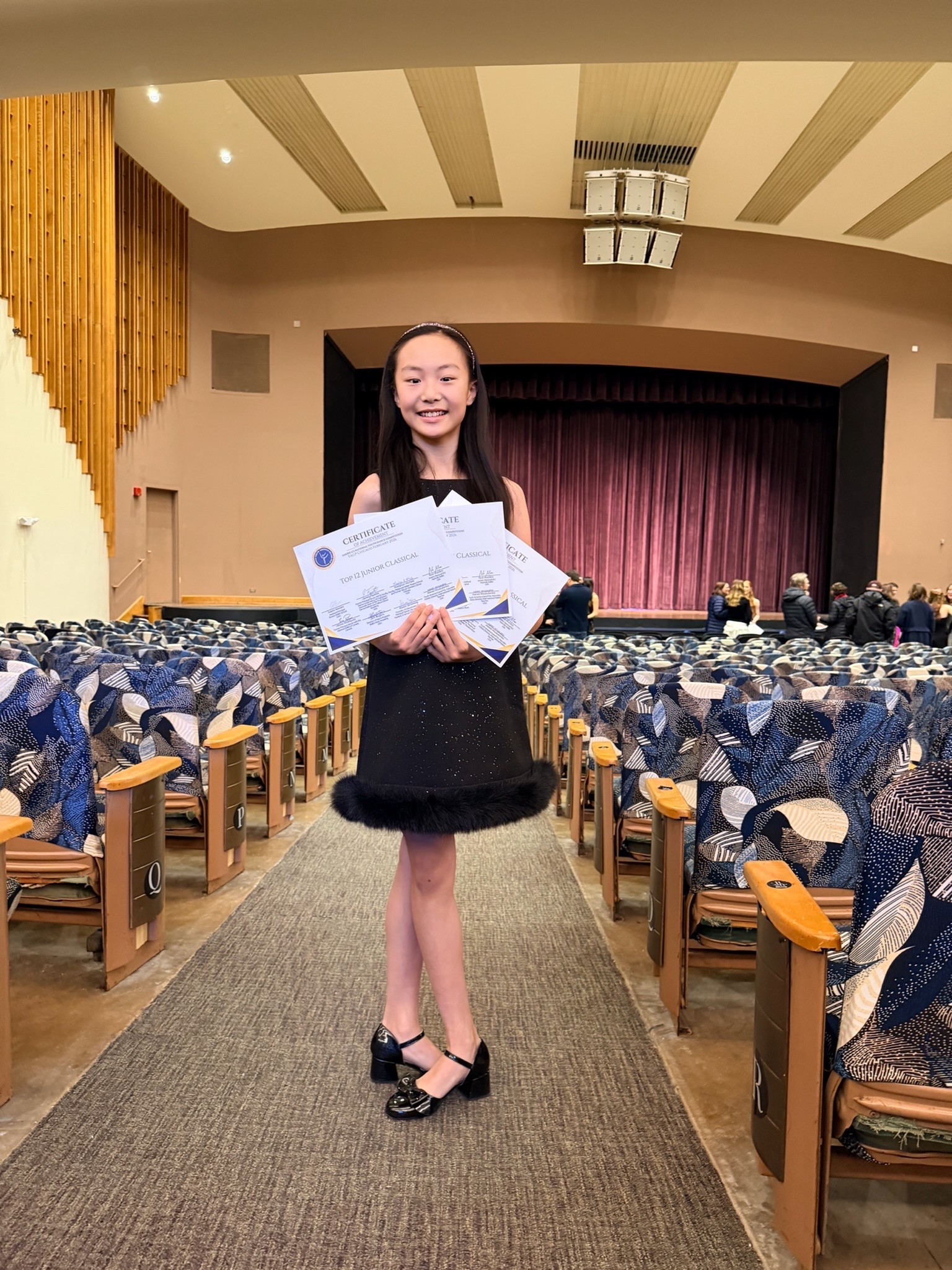 Student holding competition certificates